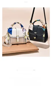 Detail of silk scarf handles and gold heart buckle on mini embossed leather bags