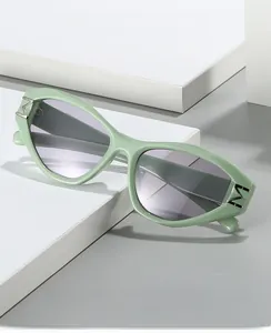 Detail view of mint green sunglasses with silver M logo hinge and gradient grey lenses