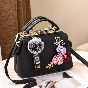 Minimalistische schwarze Handtasche mit Seidenblumen und flauschigem Schlüsselanhänger