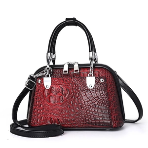 Bolso Boston de cocodrilo con degradado rojo y negro y detalles metálicos plateados