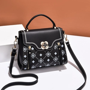 Women's black crossbody handbag with floral prints and a clover lock on 45-degree angle
