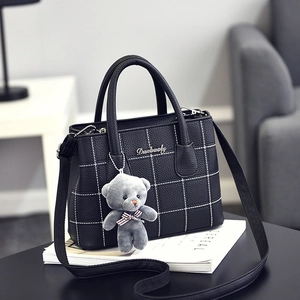 Elegante borsa a tracolla nera con trama litchi, cuciture bianche e ciondolo a orsetto
