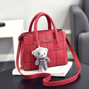 Elegante borsa rossa con trama litchi, ricamo a griglia e ciondolo a forma di orsetto