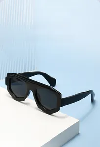 Gros plan de lunettes de soleil géométriques noires sur un support d'exposition moderne blanc