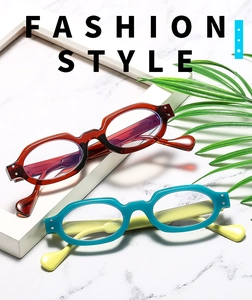 Close-up of retro oval frames in tortoiseshell red and turquoise on marble surface