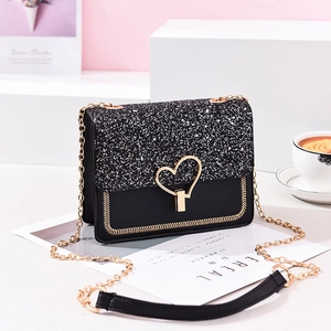Fashionable black shoulder bag with shimmering silver sequins and a gold heart buckle