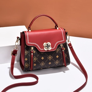 Red and brown patchwork crossbody bag with monogram pattern and floral metal buckle