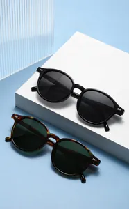 Detail of retro round sunglasses in black and tortoiseshell finish with metal rivets