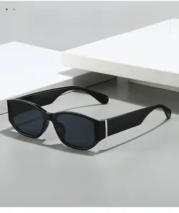 Detail of black oval sunglasses with silver metal trim on elegant white geometric props