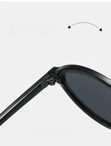 Detail of durable metal hinges on black oval sunglasses showing folding mechanism