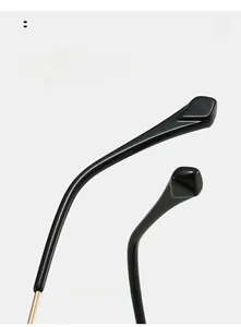 Close-up of ergonomic curved black temple tips with golden metal hinge for sunglasses