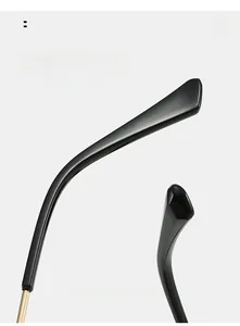 Detail of curved black mirror legs with golden metal hinges for comfortable wear