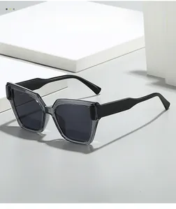 Détail de lunettes de soleil carrées avec verres gris foncé sur pierre blanche