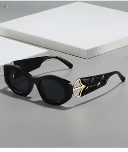 Detail of black cat eye sunglasses featuring gold metal accents and textured temples