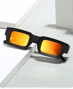 Détail des lunettes de soleil rétro 2025 avec monture noire mate et verres miroirs orange