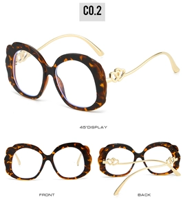 Détail de lunettes en écaille avec décor de cœur doré et bordure ondulée élégante