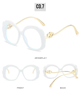 Détail des lunettes de soleil à monture ondulée blanche avec branches dorées à double cœur