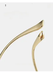 Détail des branches courbées en métal doré pour un maintien ergonomique confortable