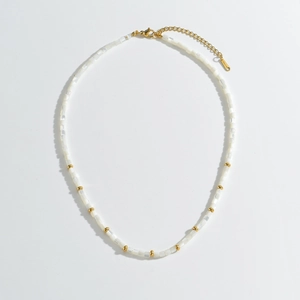 Collier en perles beiges style bohème avec reflets nacrés et détails en acier doré