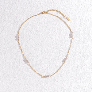 Detail of gold chain necklace featuring grey translucent beads and adjustable lobster clasp