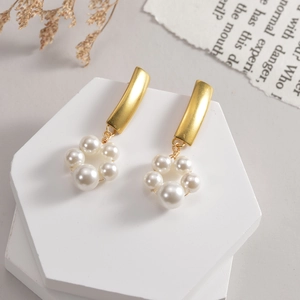 Vue détaillée de boucles d'oreilles dorées brossées avec pendentifs en perles blanches