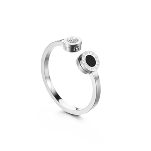 Detail of silver open ring featuring a sparkling zircon and black roman numeral disc