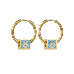 Polished gold cube earrings with blue enamel devil eye design on white background