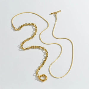 Detail of gold snake chain necklace with OT toggle clasp and geometric hollow pendant
