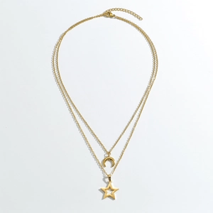 Detail of gold double-layered necklace featuring crescent moon and hollow star pendants
