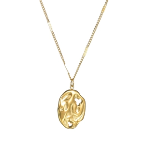 Detailed view of a gold-plated irregular lava textured pendant on a fine link chain necklace