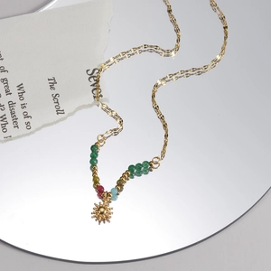 French style sun pendant necklace with colorful beads on a mirror reflection surface