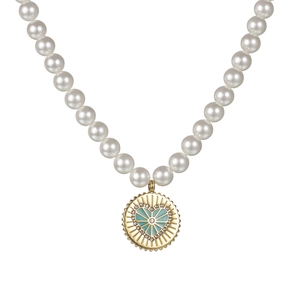 Dettaglio collana di perle con ciondolo dorato, cuore smaltato e cristalli brillanti