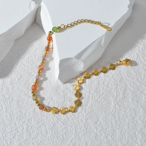 Minimalist gold stainless steel bracelet featuring colorful beads and shell links