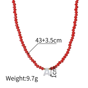 Collier à perles rouges avec lettre A et détails dorés sur un fond blanc pur
