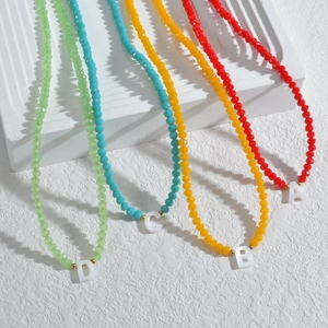 Colliers de perles colorées avec pendentifs lettres en rouge, jaune, bleu et vert