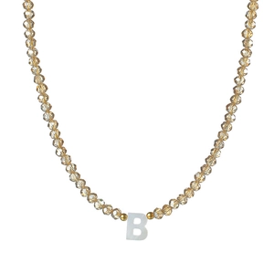 Détail du collier de perles facettées champagne avec pendentif lettre B en nacre
