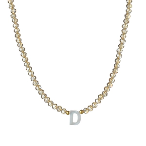 Détail du collier de perles ambrées à facettes avec un pendentif lettre D en nacre blanche