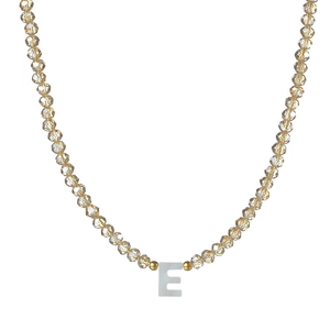Détail des perles en cristal champagne et pendentif lettre E en nacre sur collier