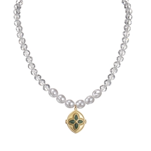 Collier à pendentif ovale doré avec pierre verte et perles mixtes sur fond blanc