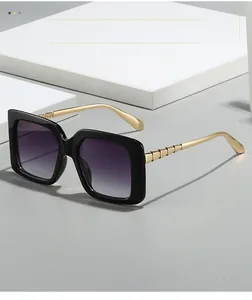 Detail of square sunglasses with gradient lenses and textured gold metal temples