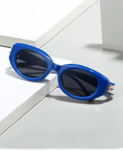 Detail view of blue cat-eye sunglasses with golden metal hinges on a geometric stand