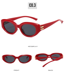 Detail view of red oval cat-eye sunglasses with golden metal hinges and dark lenses