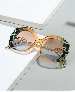 Detail of scalloped edge frame with golden heart inlay and tricolor tortoise pattern