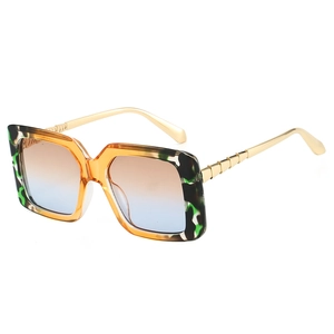 Fashionable oversized square sunglasses with tortoiseshell marble frames and gold temples