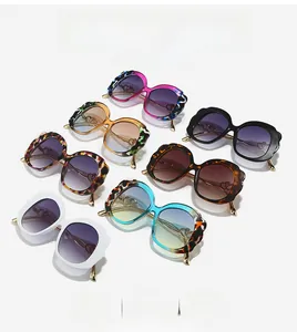 Detail of oval sunglasses featuring gold metal temples and double heart cutout accents