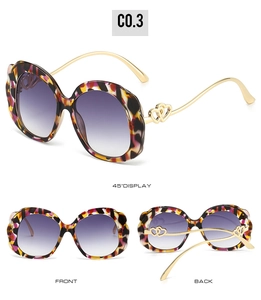 Detail of tortoise shell sunglasses with heart-shaped cutout and purple gradient lenses