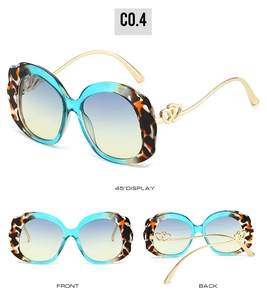 Detail view of oval sunglasses with wavy tortoiseshell frames and dual heart gold temples