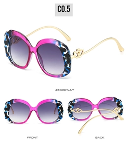 Detail of trendy oval sunglasses with pink camo frames and golden heart-shaped hinges