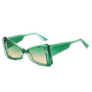 Modern oversized geometric cat-eye sunglasses with green translucent frame and gradient lenses