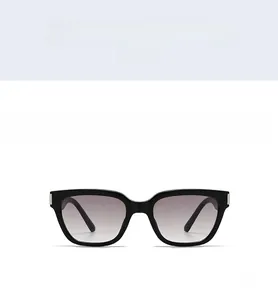 Gros plan sur lunettes de soleil carrées noires avec rivets et verres dégradés gris